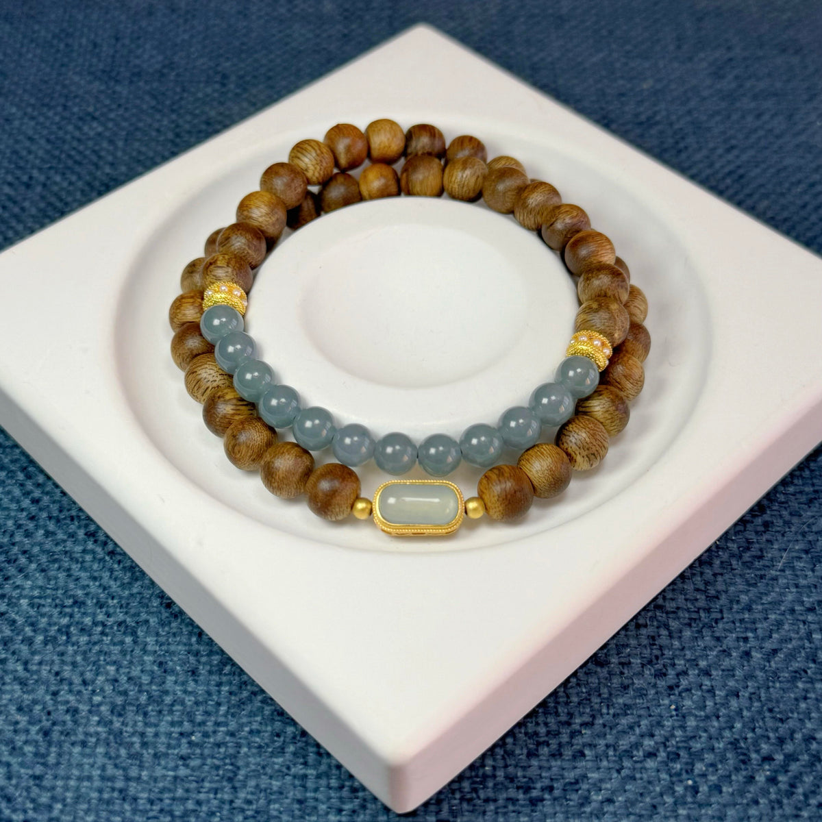 A double-wrap 7mm Hainan Yingge-Green Qinan Agarwood bracelet accented with 6mm blue-water jadeite